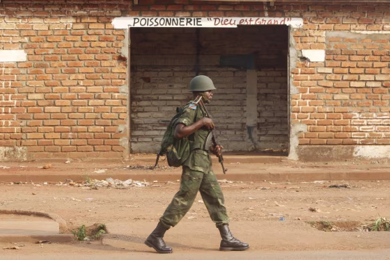 Image: A Democratic Republic of the Congo soldier, part of an African peacekeeping force, patrols beside a looted shop in Bangui