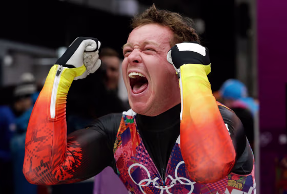 Image: Felix Loch of Germany celebrates after he crossed the finish area to win the gold medal during the men's singles luge final
