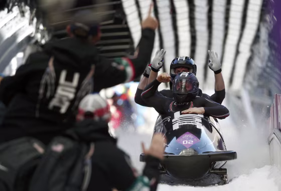 Image: Pilot Holcomb and his teammates of the U.S. react after a heat of the four-man bobsleigh event at the Sochi 2014 Winter Olympics