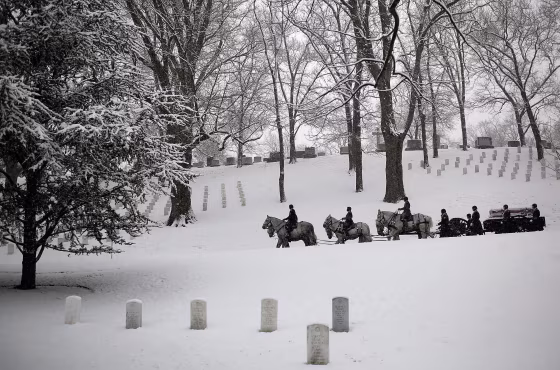 ARLINGTON, VA - FEBRUARY 25:  A burial team leads a horse drawn caisson through a snow covered Arlington National Cemetery on February 25, 2014 in Arlington, Virginia. The Washington DC area received about an inch of snow this morning, adding to an already significant total for the winter.  (Photo by Win McNamee/Getty Images)