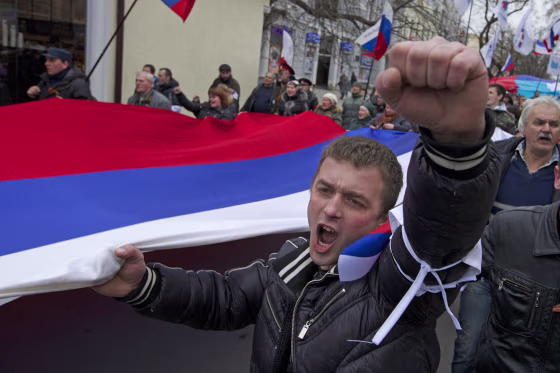 Image: Local residents carry Russian flags as they rally in the streets of Crimean capital of Simferopol on Saturday.