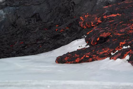 Image: Lava flows on top of snow at Tolbachik volcano in Russia in April 2013.