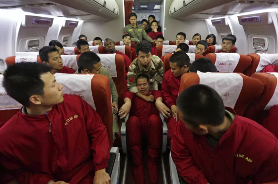 Image: An instructor holds a student by his neck during a special course on flight safety on the outskirts of Beijing