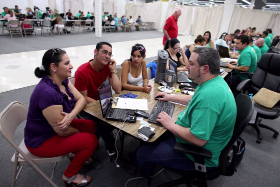 Image: People purchase health insurance from an agent from Sunshine Life and Health Advisors in Miami.