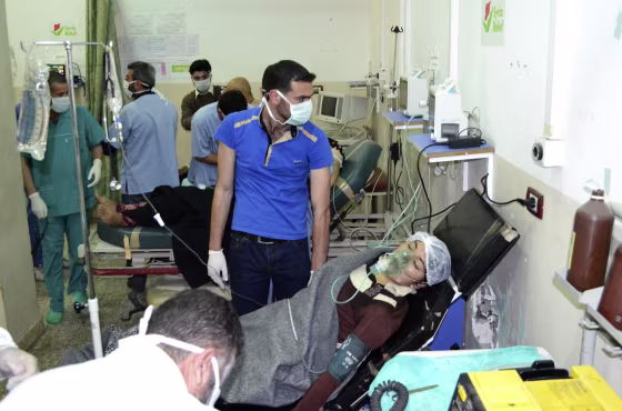 Image: A woman breathes through an oxygen mask at Bab al-Hawa hospital close to the Turkish border