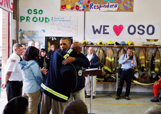 Image: U.S. President Barack Obama hugs a first responder after touring the mud slide damage in Oso, Washington