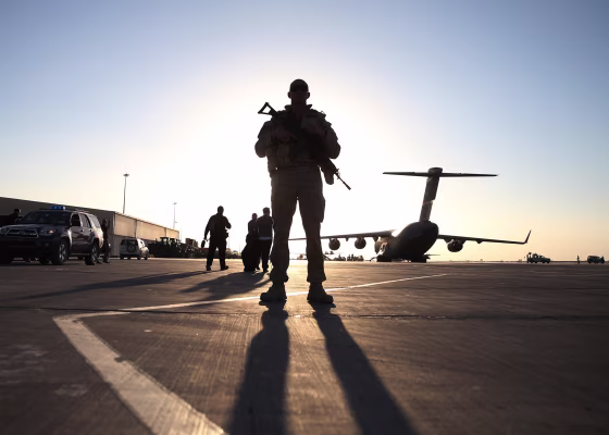 Image: A soldier stands guard near a military aircraft in Kandahar