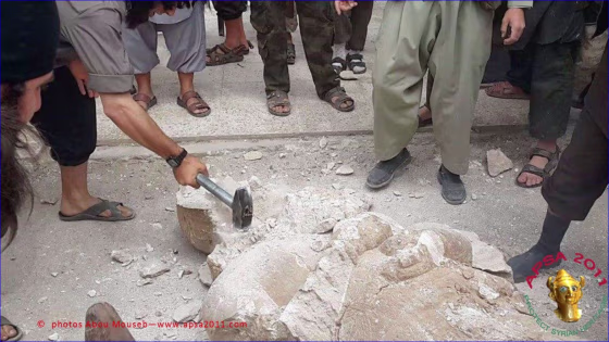 According to a report from the website www.apsa2011.com, this image shows members of the Islamic State of Iraq and the Levant (ISIL, also known as ISIS) destroying an Assyrian statue believed to be 3,000 years old.