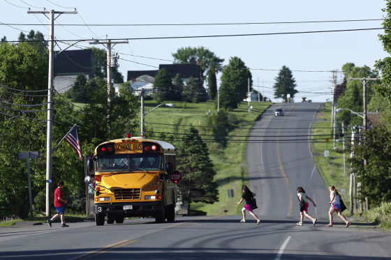Image: Students run to school on Rte. 1 on their way to the Wellington public school in Monticello, Maine, on June 16.