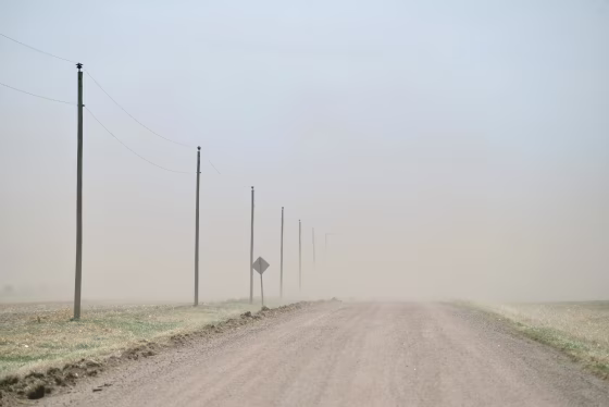 Image: The relentless Kansas wind strips a dry, bare field and sends the topsoil to obscure a county road