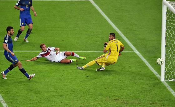Image: Germany's forward Mario Goetze shoots and scores past Argentina's goalkeeper Sergio Romero