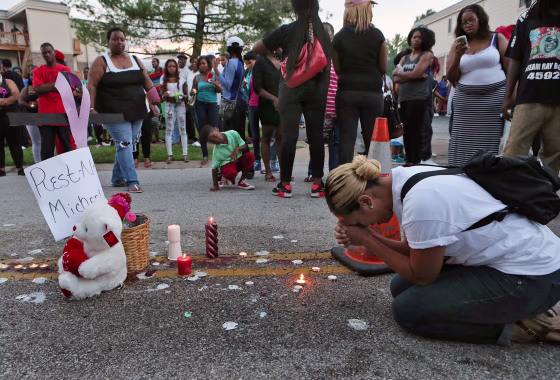 Meghan O'Donnell, 29, from St. Louis, prays on Sunday night at the spot where Michael Brown was killed earlier in the weekend.