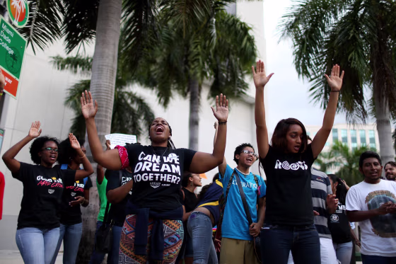 Protesters raise their arms and shout "hands up, don't shoot" outside the James Lawrence King Federal Justice Building where the U.S. Attorneys Office, Southern District of Florida, is located on August 14, 2014 in Miami, Florida. The protesters, which included members of the civil rights group Dream Defenders, say they want justice for Mike Brown, shot and killed by police in Ferguson, Missouri on August 9. They said they also want justice for 17-year old graffiti artist Israel Hernandez, who died from shock from a Miami Beach police officer's Taser last summer.
