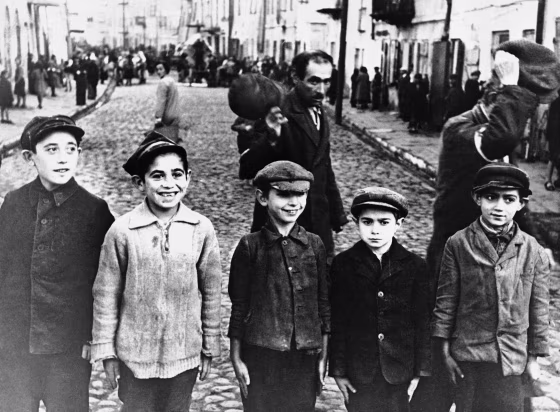 Men of the Lublin ghetto, behind boys, wear arm bands earmarking them as Jews, shown during the German occupation of Poland.