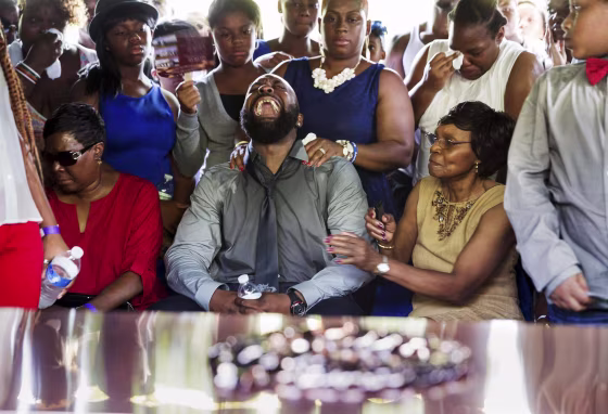 Image: Michael Brown Sr. yells out as his son's casket is lowered into the ground at St. Peter's Cemetery in St. Louis