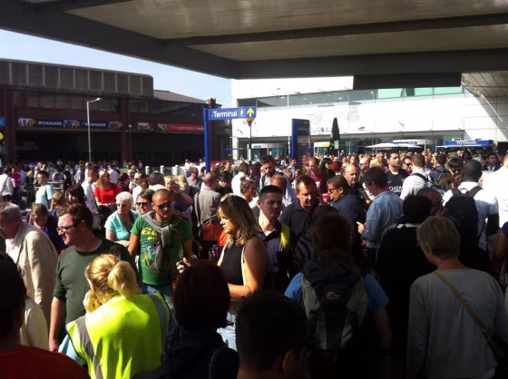 Passengers crowd outside Luton airport after a security alert.