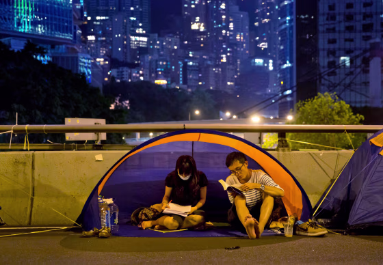 Image: A couple read inside their tent at the occupied area in Central, Hong Kong