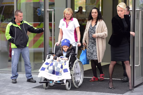 A medic wheels five-year-old Ashya King who suffers from brain tumor to an ambulance car on October 24, 2014 in Prague. Five-year-old British brain tumor patient Ashya King is feeling better after 30 sessions proton therapy in Prague and is now heading back to Spain, his doctor said. King's case made headlines after his parents removed him from a hospital in Britain in August 2014 against doctors' wishes, sparking an international manhunt. 