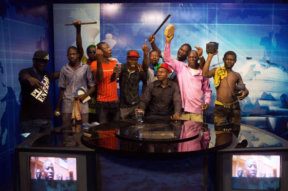 Image: Anti-government protesters take over the state TV podium in Ouagadougou