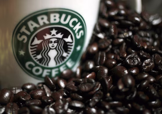 Image: Mug with Starbucks logo next to coffee beans