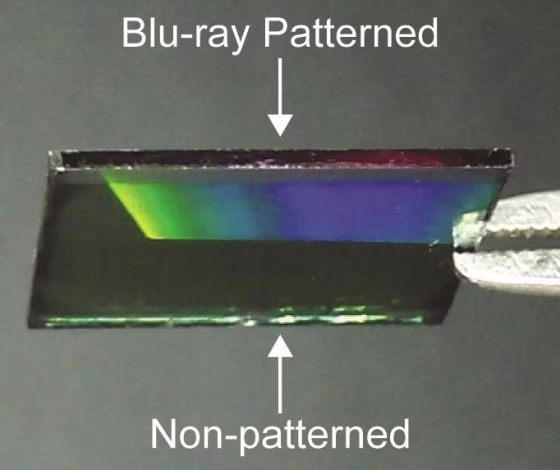 A surface partly covered by the Blu-ray pattern that shows how it diffuses light (as shown by the rainbow gradient).