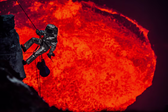 A man wearing a protective suit descends the rim of the lava lake in Marum, Vanuatu.