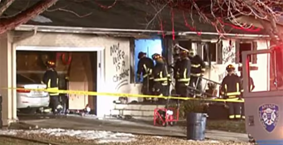 "My wife is a cheater" is written on the side of a house as fire fighters respond to a fire in Arvada, Colo.