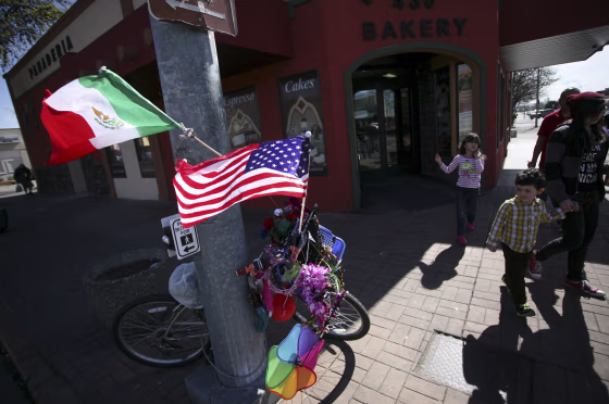 Image: Passers-by look at a bike adorned with trinkets and Mexican and the U.S. flags in Pasco, Washington