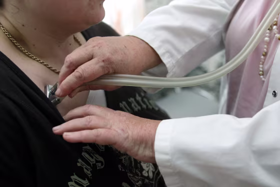 Image: A doctor auscultates a patient with a stethoscope