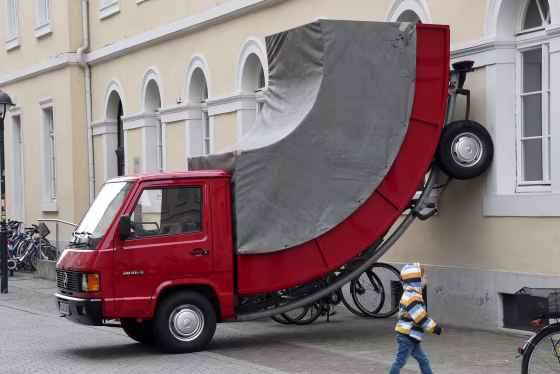 A child walks past the work 'Truck' by Austrian artist Erwin Wurm in Karlsruhe, Germany, on Sunday.