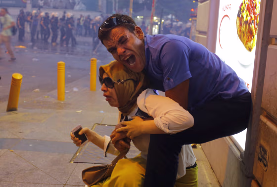 Image: A couple, affected by tear gas used by riot police to disperse demonstrators, reacts in central Istanbul, Turkey,