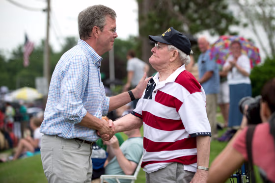 Image: Republican presidential candidate, former Florida Governor Jeb Bush, (L) talks with World War Two veteran Joseph McBreen, 90, along the Independence Day parade route in Merrimack, New Hampshire