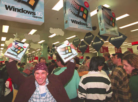 Image: Mikol Furneaux waves two packages of Windows 95 software in the first store in Australia to sell the product