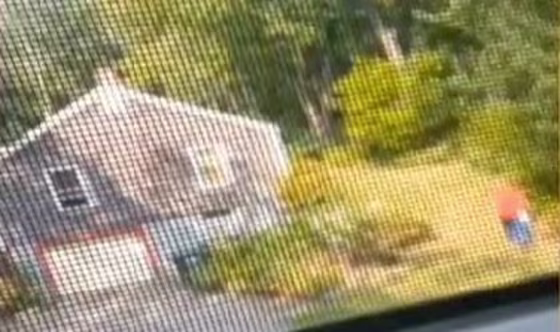 An image from the video the 12-year-old girl shot from the upstairs window of her home. She was hiding there when the man in the red shirt allegedly tried to break in.