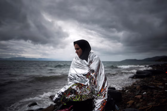 Image: A woman tries to warm up herself using a thermal blanket