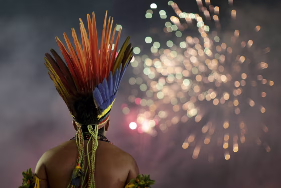 Image: An indigenous man watches fireworks during the first World Games for Indigenous Peoples in Palmas