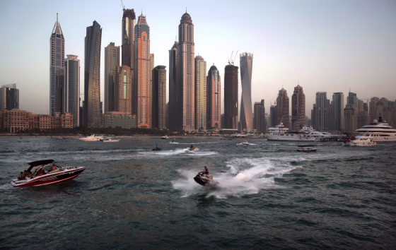 Image: People use recreational vehicles opposite the Marina district of Dubai