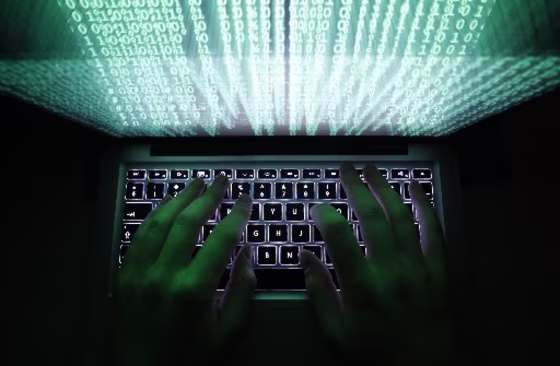 Image: Man types on a computer keyboard