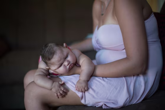 Image: Gleyse Kelly da Silva holds her daughter Maria Giovanna as she sleeps in their house in Recife
