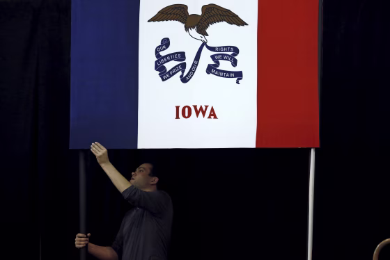 Image: A campaign worker hangs a flag for a U.S. Republican presidential candidate Ted Cruz campaign event in Des Moines
