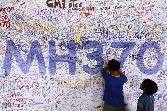 Image: Children write well-wishes on a banner for the missing Malaysia Airlines Flight MH370 at Kuala Lumpur International Airport