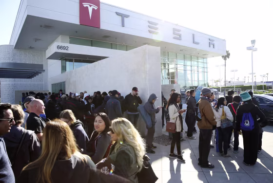 Image: Car buyers wait in line at the Tesla dealer
