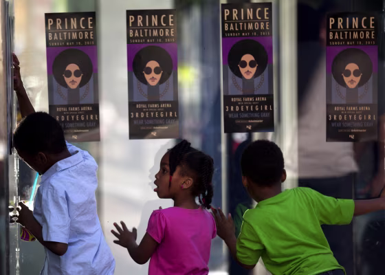 Children look through glass as fans of musical artist Prince enter a "Rally 4 Peace" concert in Baltimore, Maryland on May 10, 2015.