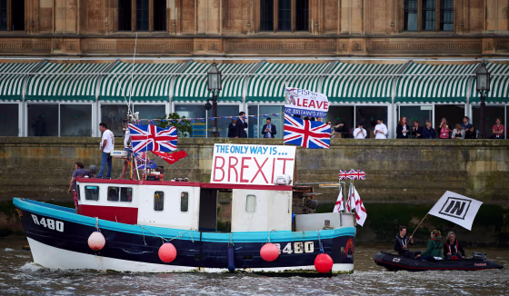 Image: A boat decorated with flags and banners from the 'Fishing for Leave' group