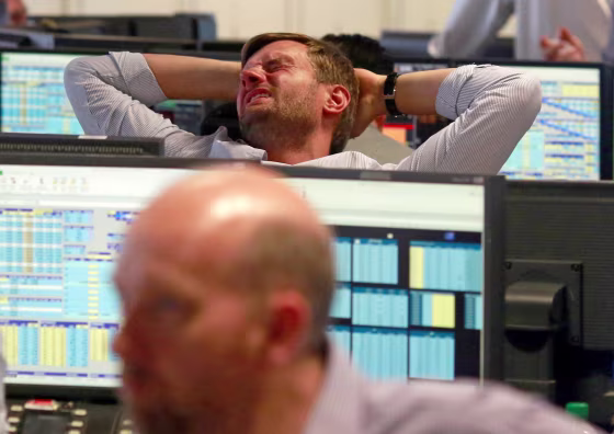 Image: A trader from BGC, a global brokerage company in London's Canary Wharf financial centre reacts during trading
