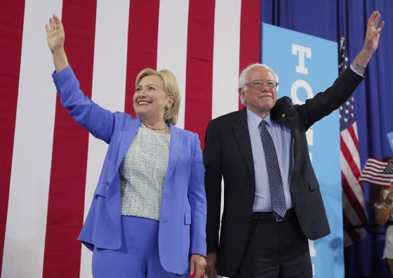Image: Democratic U.S. presidential candidates Clinton and Sanders stand together during campaign rally in Portsmouth, New Hampshire