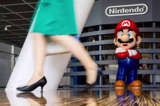 Woman walks past figure of "Mario" video game character at Nintendo centre in Tokyo