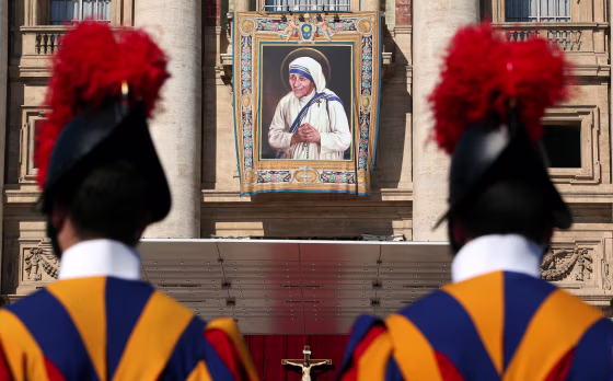 Image: Swiss Guards stand in front of a tapestry depicting Teresa of Calcutta before a mass