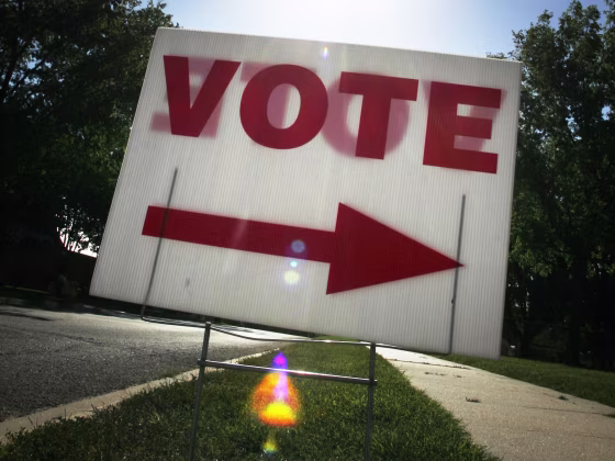 In this Tuesday, Aug. 3, 2010 file photo, the sun shines behind a voting sign outside a polling location in Lawrence, Kan.