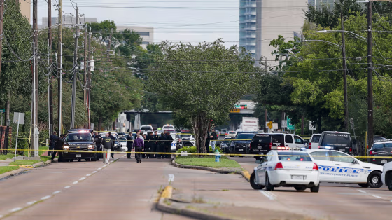 Image: Investigators look over the scene where nine individuals were shot at a strip mall
